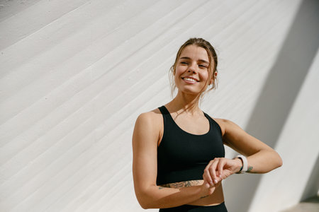 Young athlete woman looking at smartwatch and counting calories burned. Healthy life conceptの写真素材