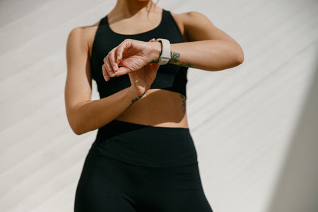 Close up of woman in sportswear looking on smartwatch after training. Outdoor sports in the morningの写真素材
