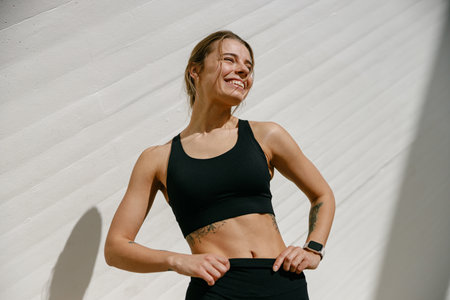 Young female athlete in sportswear have a rest after morning jogging outside and looks awayの写真素材