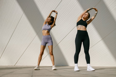 Young sportswomen in tracksuit are stretching outdoor and preparing to jogging. Healthy life conceptの写真素材