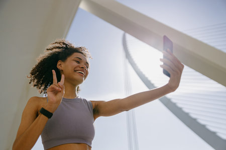 Smiling female athlete making selfie on a smart phone after morning run outdoorsの写真素材