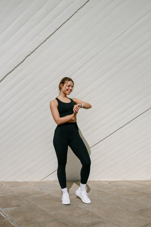 Young athlete woman looking at smartwatch and counting calories burned. Healthy life conceptの写真素材