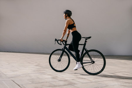 Side view of sporty young woman with bicycle do sports activity. Healthy lifestyle conceptの写真素材