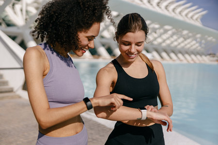 Young fit women looking at smartwatch and counting calories burned. Healthy life concept