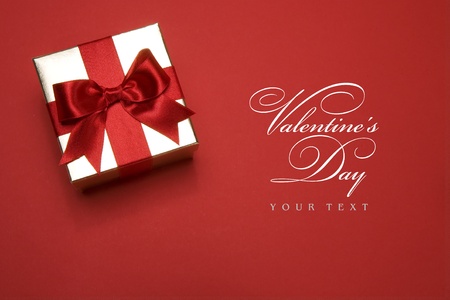 golden gift box with a red bow on red background golden gift box with a red bow on red background