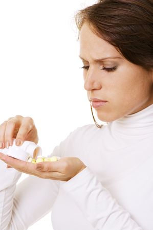 young woman pouring pills in her hand. isolated on whiteの写真素材