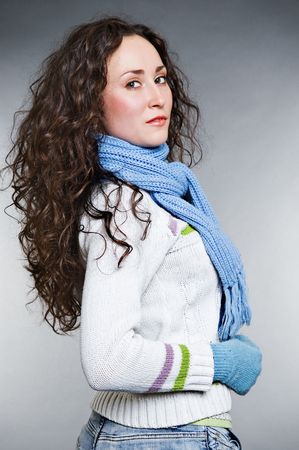 beautiful young woman with long curly hair against grey backgroundの写真素材