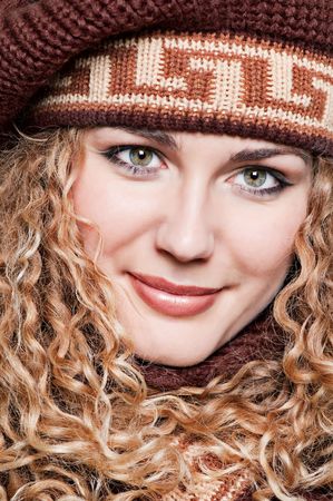 closeup portrait of smiley blond in brown knitted capの写真素材
