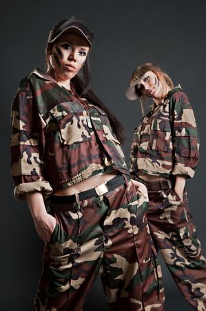 two beautiful military girls against dark backgroundの写真素材