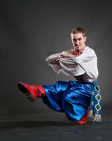 young cossack dancing over dark backgroundの写真素材