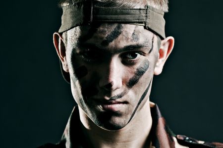 portrait of young military man against dark backgroundの写真素材