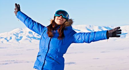 attractive happy woman against snowy mountainsの写真素材