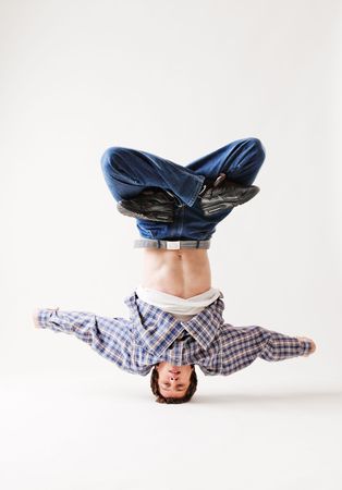 hip-hop dancer balancing on his head against white backgroundの写真素材