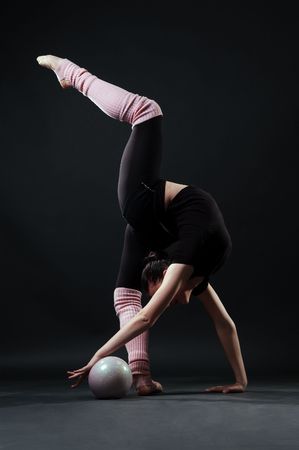 lovely gymnast with ball against dark backgroundの写真素材