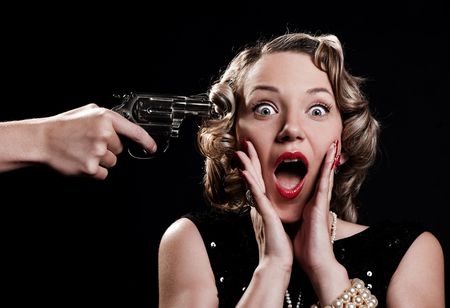 portrait of scared woman against black backgroundの写真素材