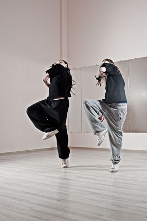 two girls dancing synchronously in dance studioの写真素材