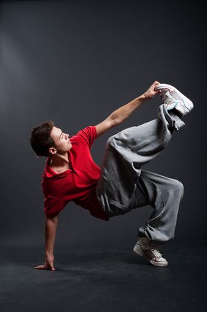 hip-hop guy dancing against dark backgroundの写真素材