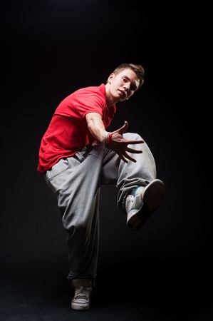 stylish guy dancing against dark backgroundの写真素材