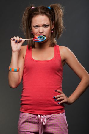 funny girl in pink top bitting motley lollipopの写真素材