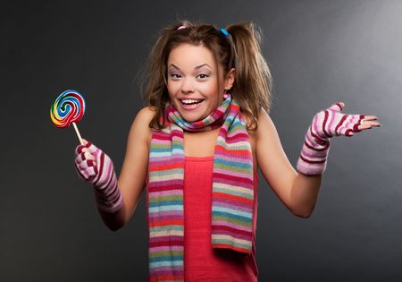 funny woman in striped scarf with lollipopの写真素材
