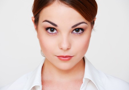 portrait of serious young woman over grey backgroundの写真素材