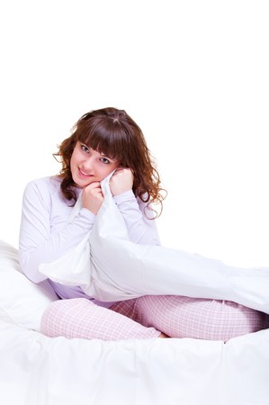 beautiful smiley woman in the bed over white background の写真素材