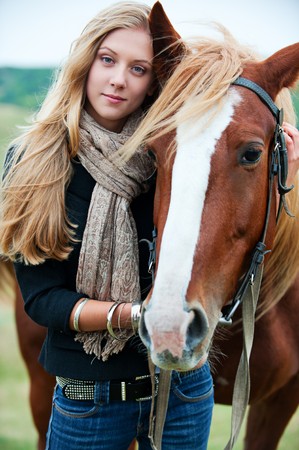 outdoor portrait of young beautiful woman with horseの写真素材