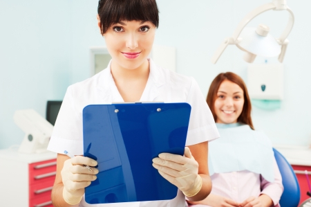 portrait of pretty smiley doctor with patient at dentist's officeの写真素材
