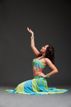 beautiful oriental dancer posing over black background の写真素材
