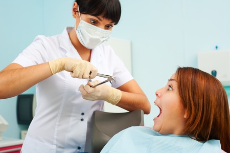 portrait of doctor and scared patient at dentist's office の写真素材