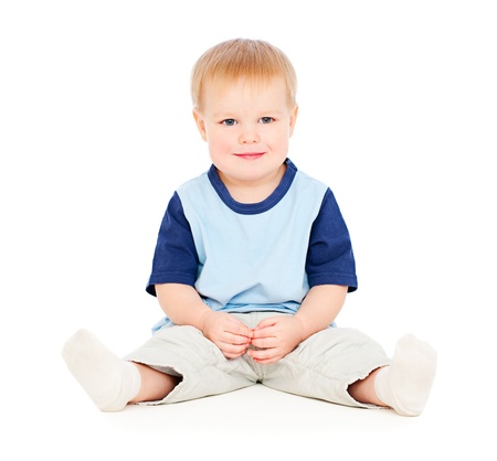 cheerful young boy sitting on floorの写真素材