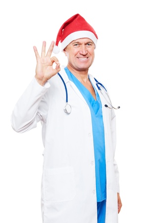 smiley doctor in red santa hat showing ok sign. isolated on white backgroundの写真素材