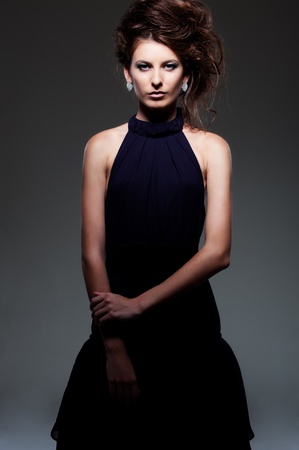 alluring woman in evening dress posing over dark background の写真素材
