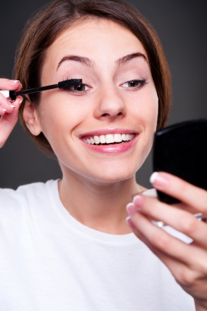 young smiley woman applying make upの写真素材