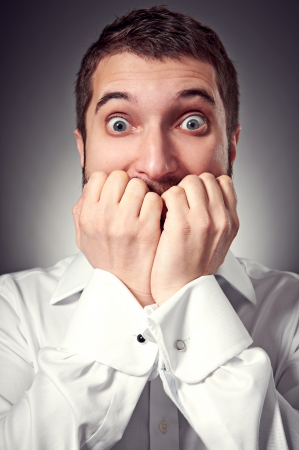 excited man have a fear of something. studio shot over dark backgroundの写真素材