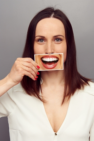 young woman hiding her true emotions in the smile. concept photoの写真素材
