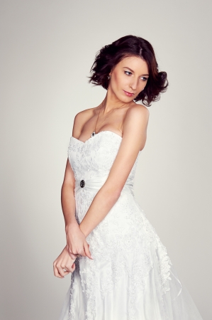beautiful young bride posing over grey backgroundの写真素材