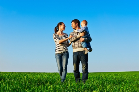 smiley and cheerful family walking at the green fieldの写真素材