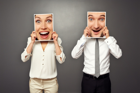 man and woman holding amazed happy faces. concept photo over grey backgroundの写真素材