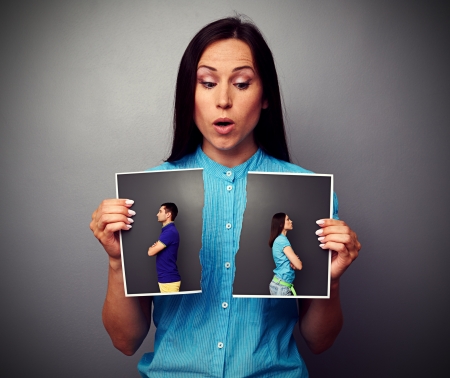 amazed woman looking at disrupt photo of couple in quarrelの写真素材