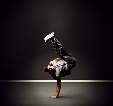 cool young dancer standing on the freeze over dark backgroundの写真素材