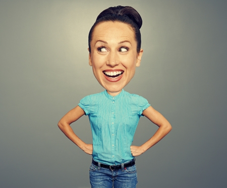 happy and funny woman with big head looking at something over grey backgroundの写真素材