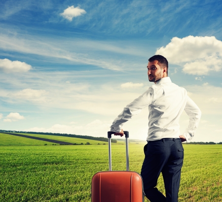 serious businessman standing on the field and looking aroundの写真素材