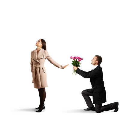young beautiful woman rejecting man with flowers. isolated on white backgroundの写真素材