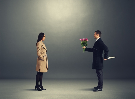 young couple on the date. crafty man holding flowers and looking at young beautiful womanの写真素材