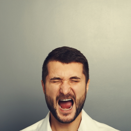 screaming man over grey backgroundの写真素材