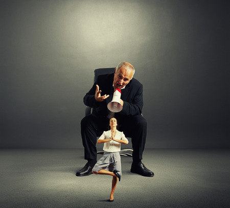 enraged boss screaming small female in dark empty roomの写真素材