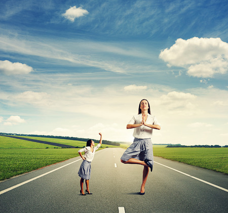 aggressive businesswoman showing fist at big calm woman on the roadの写真素材