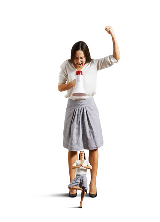 displeased woman screaming at small meditation woman. isolated on white backgroundの写真素材