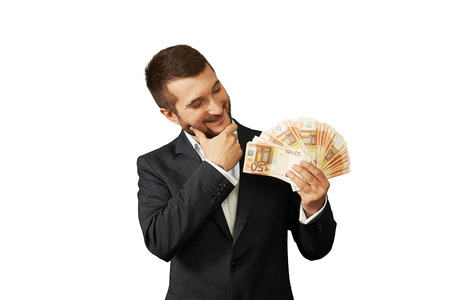 smiley businessman looking at money and thinking about something. isolated on white backgroundの写真素材